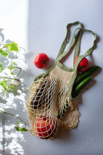 Reusable mesh shopping bag with fresh vegetables