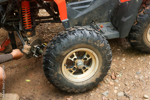 Off road vehicle tire repair maintenance wheel dirt outdoor mechanic rugged Off road vehicle tire repair maintenance with mechanic working wheel rugged outdoor setting dirt ground adventure