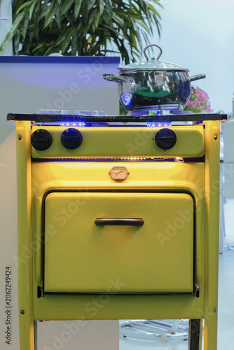The bright yellow gas stove glows under the blue lights.