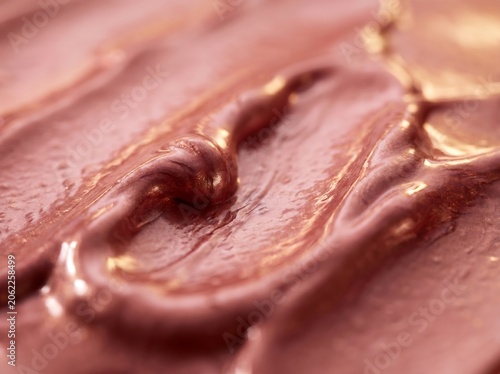 Close up of glossy melted chocolate spread with rich texture and indulgent, velvety glaze.
