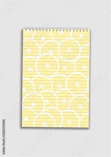 A lined spiral notebook mock-up featuring a faint yellow lemon slice pattern on its pages, isolated on a gray background.