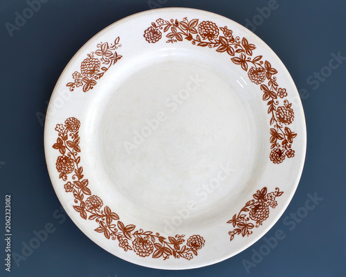 Ceramic plate with floral pattern. Empty dish for food serving. Tableware for dining and kitchen decoration.