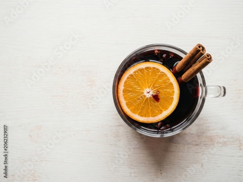 Warm mulled wine in a glass with orange slice and cinnamon sticks, a festive winter drink perfect for the holidays.