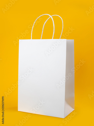 Blank White Paper Shopping Bag Mockup with Handles Isolated on Yellow Background