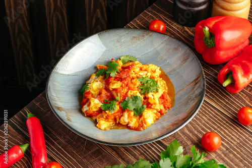Photography Spicy tomato scrambled eggs with fresh cilantro garnish