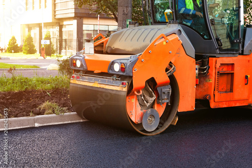 Obraz na plátně Road Roller Compacts Fresh Asphalt on a Metropolitan City Street