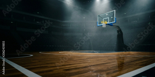 A dimly lit basketball court with a hoop and wooden floor, illuminated by spotlights in a darkened indoor arena with a sleek, modern aesthetic.
