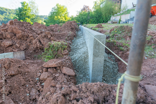 Concrete curb installation in a garden. Landscaping construction of a concrete edge