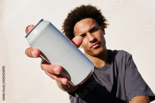 Young man holding blank can
