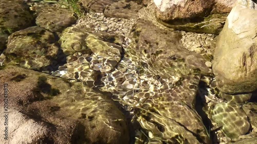 Abstract light reflections on flowing stream water, natural motion background