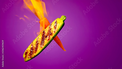 Charred Zucchini and Carrot in Mid-Air with Dramatic BBQ Fire on Purple Background Braai Photography Scene