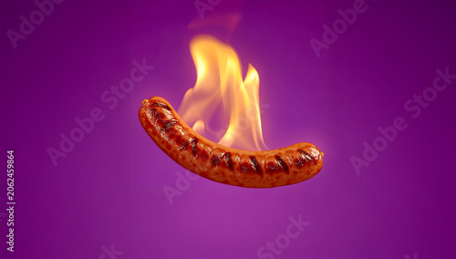 Flaming BBQ Grilled Sausage Floating on Purple Background in Dynamic Barbecue Braai Food Photography Scene