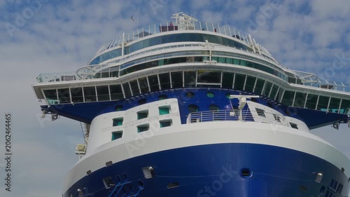 Close up view of the massive blue and white hull and multi-level passenger decks of a luxury cruise ship sailing in the waters of Istanbul under a bright sky