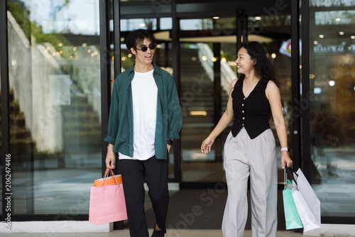 Happy Couple Walking Out of Shopping Mall with Bags – Modern Urban Lifestyle