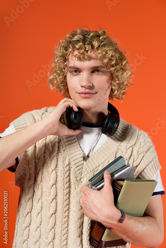 Konstfotografi Blonde curly student showcasing his trendy casual style in a vibrant studio sett