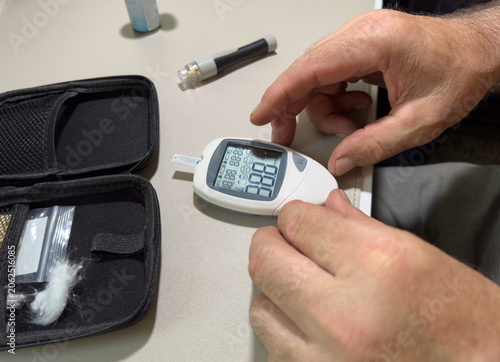 Fotografía Hands checking blood glucose meter with test strip