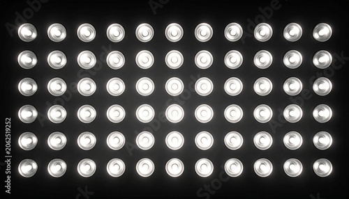 A wide angle view of a dark wall illuminated by a grid of bright round spotlights creating a dramatic stage lighting effect for events.