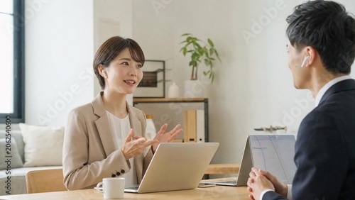 Professional Business Meeting with Colleagues Discussing Work on Laptops