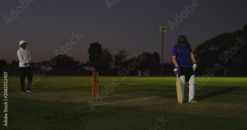 Indian umpire raising finger signaling out, ball hitting stumps batsman taking guard on pitch
