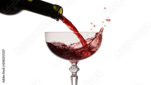 фотографія Red wine pouring from bottle into crystal glass creating splash