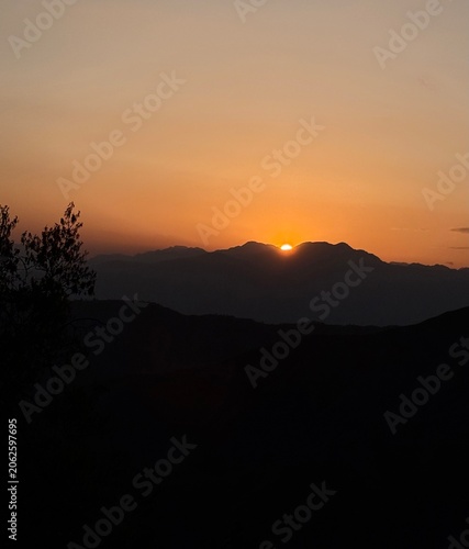 The sun leaves quietly, painting the mountains with its last light.