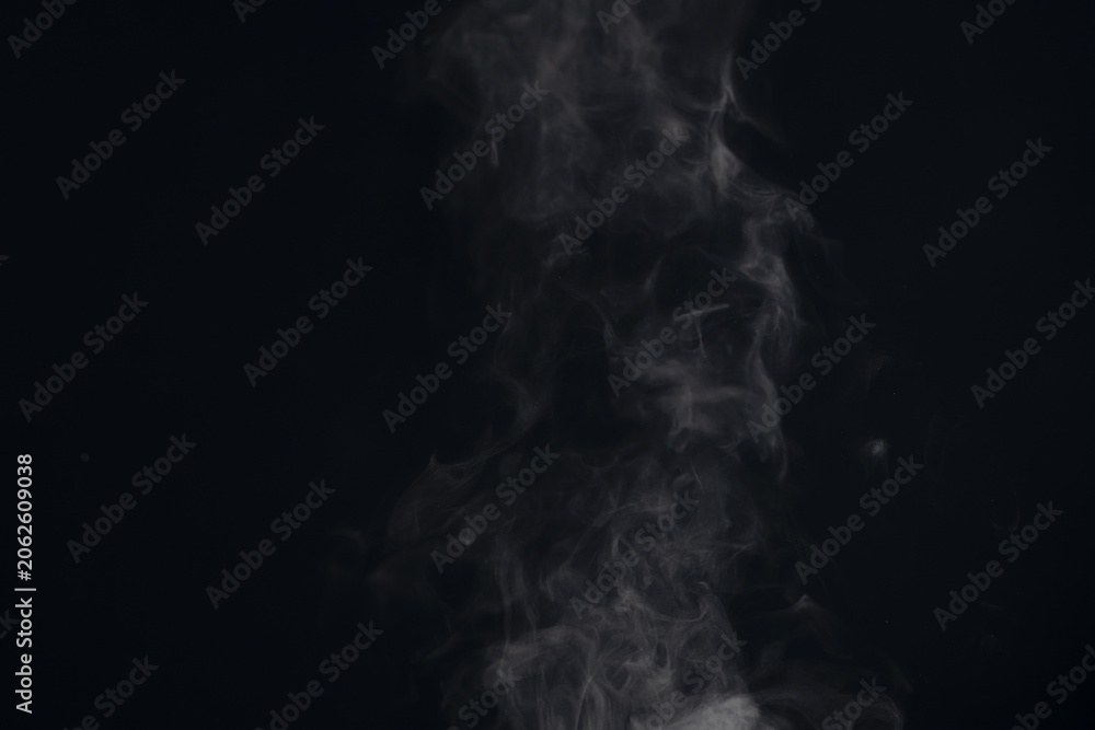 Fototapeta premium White steam smoke rising and swirling on a black background