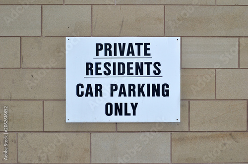 Close Up of Sign on Concrete Wall of Car Park 'Private Residents Car Parking Only' 