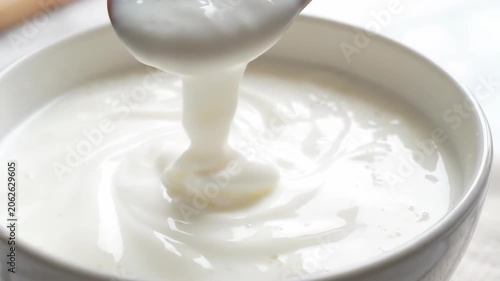 Wooden spoon yogurt dairy white creamy bowl closeup swirl texture fresh breakfast kefir fermented milk probiotic drink healthy snack minimal style