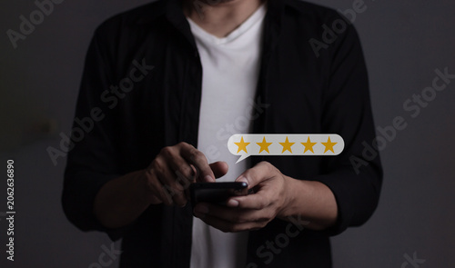 Customer Review, Young Man hand holding Smart Phone with five star to review and give 5 stars with very good results in service, Good review 5 star rating choice feedback
