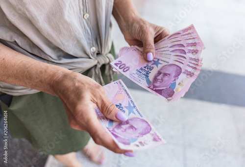 Fotografía A senior person holds several Turkish lira banknotes in their hands