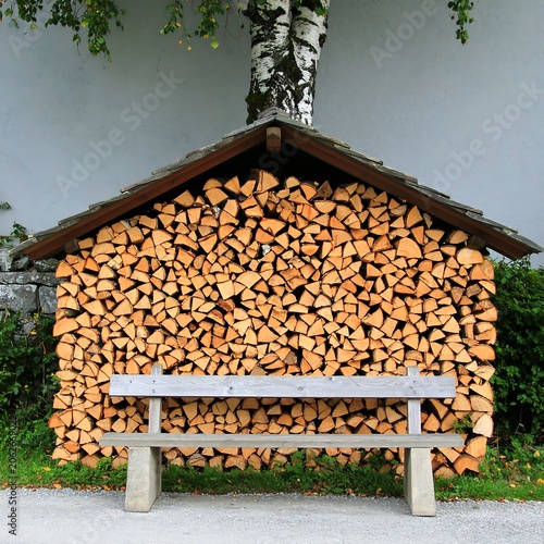 Wooden logs stacked high, rustic bench
