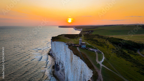 Obraz na płótnie Beachy Head Lighthouse perched on dramatic white chalk cliffs during sunset, overlooking the English Channel on the East Sussex coast, England