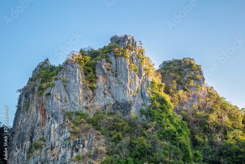 Limestone cliffs at Ao Phra Nang beach, at Railay in Krabi, southern Thailand. Blue morning sky in the background. 
