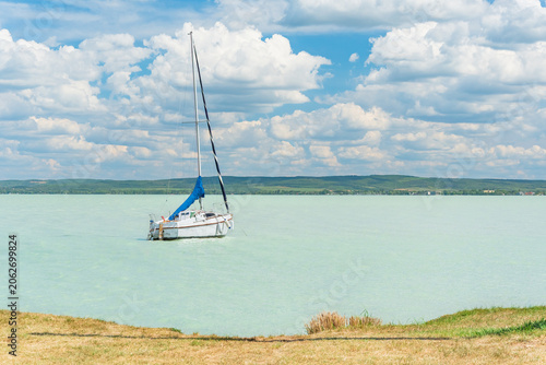 Hungary, Lake Balaton, sailboat moored on the water, view of the other side of the lake on a sunny summer day.