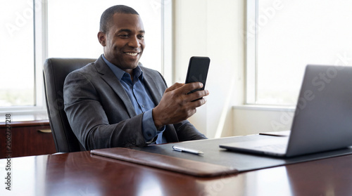 Professional Man Using Smartphone in Modern Office Environment Featuring Businessman, Technology, Communication, Corporate, Executive and Smiling