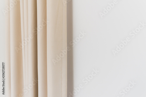 Tableau sur toile Closeup of beige curtain fabric with vertical pleats and hem detail