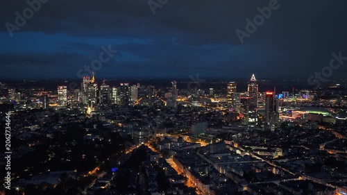 Frankfurt skyline glowing with office lights during twilight, city's dynamic urban landscape and modern architecture under evening sky in financial center