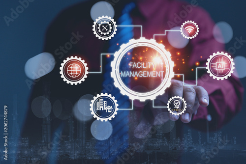 A businessman touches glowing digital interface displaying FACILITY MANAGEMENT with artificial intelligence and maintenance tools.
