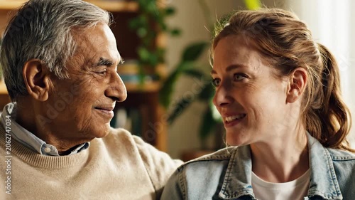 Loving senior man and woman sharing a happy smile and looking affectionately at each other in a warm home setting.