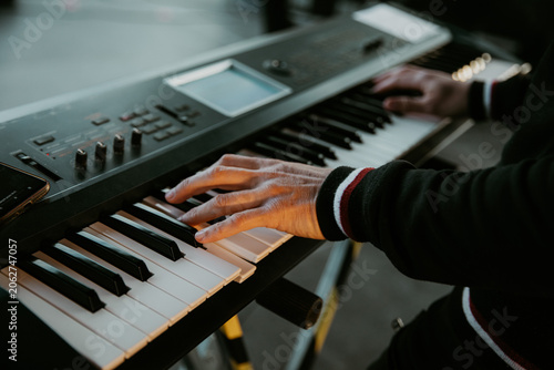 Fotografie Close up of a musician hands playing an electronic keyboard synthesizer on stage