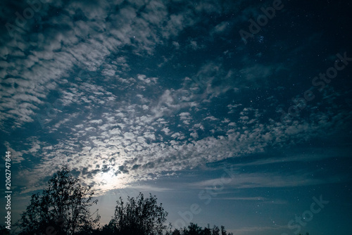 Canvas Print Moonlight glowing through altocumulus clouds at night