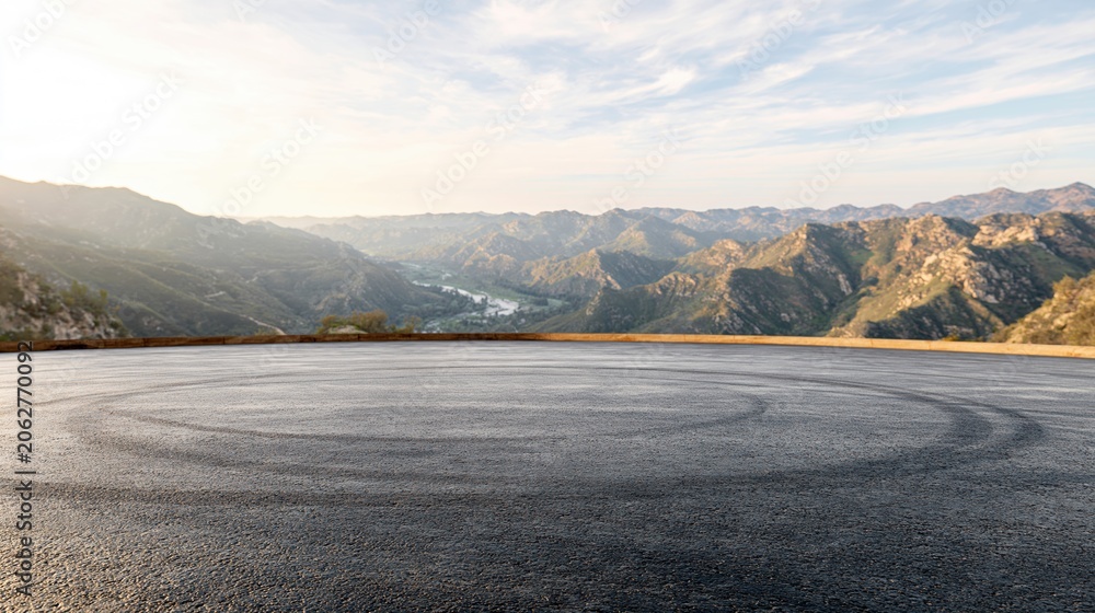Naklejka premium Scenic mountain vista with paved asphalt surface and tire marks, ideal for automotive or travel themes