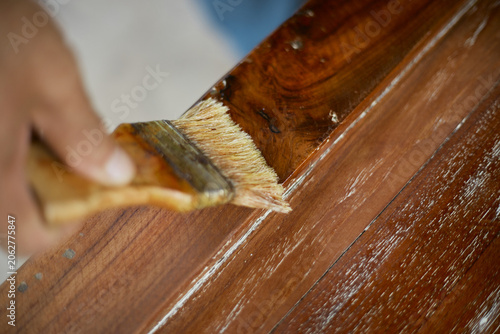 hand applying stain on wood