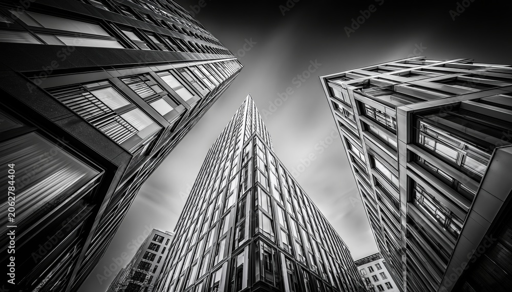 Fototapeta premium Dramatic Black and White Low Angle View of Modern Office Buildings Reaching Towards the Sky