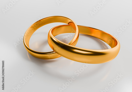 Two gold wedding rings interlinked as a concept of love marriage and eternal union