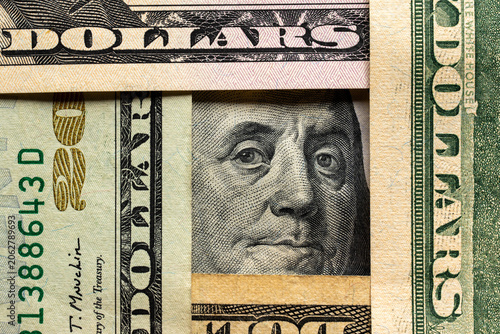 Foto Macro close-up of Benjamin Franklin portrait on a one hundred dollar bill framed by overlapping US currency denominations