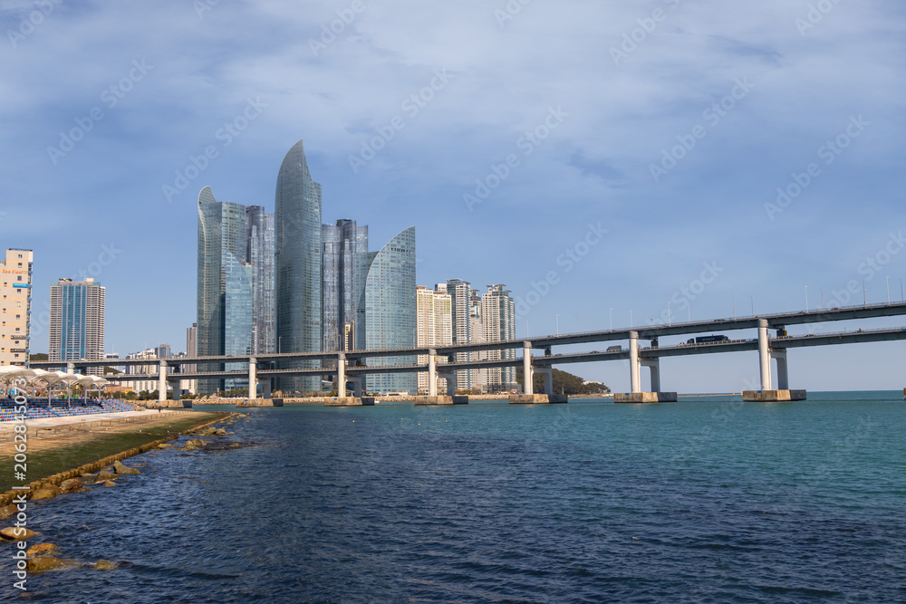 Obraz premium Scenic view of Gwangan Bridge and Marine City modern skyscraper skyline with blue sea in Busan, South Korea.