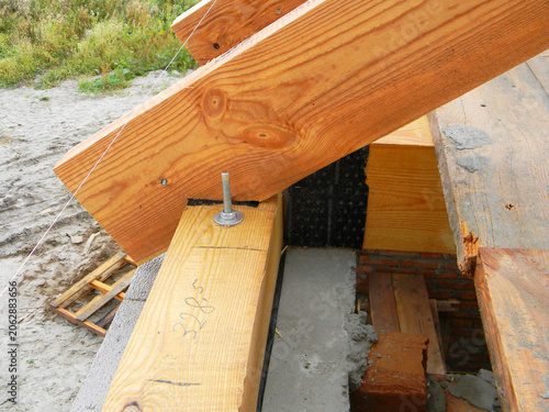 Roof framing timber beam anchoring to wall with waterproofing membrane