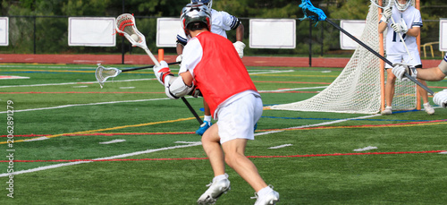 Players Practice Lacrosse Skills on a Field in Sunny Weather