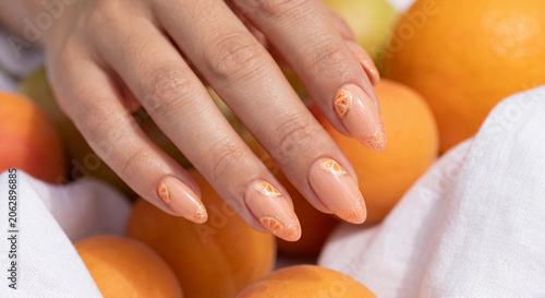 orange citrus nail art manicure with fruit slices and gold glitter french tips design
